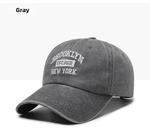 Close-up of white Brooklyn embroidery on dark grey washed cotton baseball cap