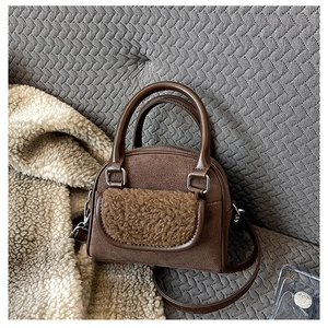 Detail of a brown plush tote bag with sherpa pocket and premium faux leather contrast
