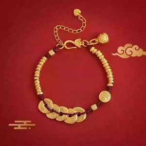 Gros plan du bracelet en corde rouge avec perles dorées et breloques de pièces Fu