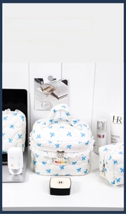 Detailed set of quilted makeup bags with blue bow patterns and lace trim highlights