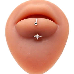Macro shot of stainless steel lip ring with silver octagram star on a silicone model