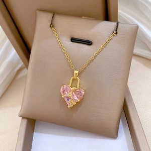 Détail du collier pendentif cœur rose finition dorée dans un coffret de présentation