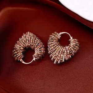 Créoles de luxe en or rose avec perles de verre ambré sur fond de soie vintage