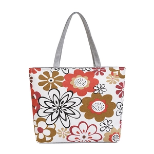 Close-up of canvas tote bag showing grey strap and large floral prints on white fabric