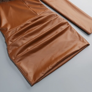 Détail de la robe en similicuir marron montrant les plis et le col en fausse fourrure