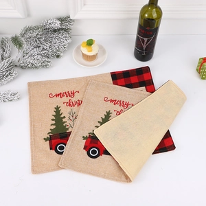 Close-up of linen Christmas placemats with red truck and festive embroidery patterns