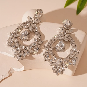 Macro shot of sparkling silver drop earrings with floral rhinestones and crystal details