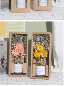 Detail of pink and yellow dried flowers in glass bottles with hemp rope bow gift packaging