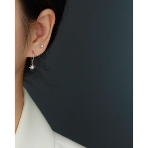 Close-up of S925 sterling silver star drop earrings with sparkling zircon on model