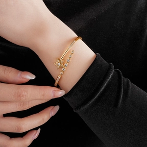 Macro detail of gold-plated star bracelet with cubic zirconia on black velvet
