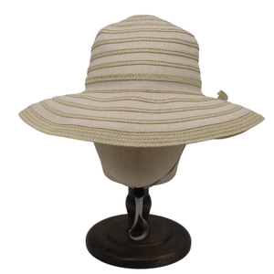 Detail of beige straw sun hat showing textured stripes and adjustable chin strap
