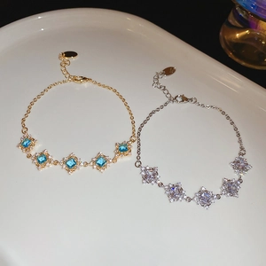 Close-up of gold and silver geometric square zircon bracelets with lobster clasp and chain