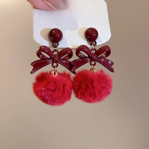 Dettaglio di graziosi orecchini con pallina di peluche rossa, fiocco e perno in argento 925