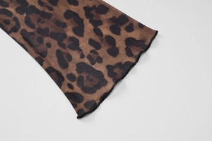 Close-up of leopard print sheer mesh fabric featuring elegant lettuce trim edges