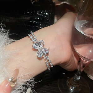 Detailed macro view of the double-layered silver bracelet with sparkling zircon butterfly charm