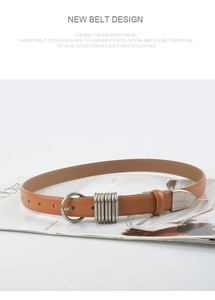 Macro shot of brown leather belt featuring silver round buckle and spiral metal loop