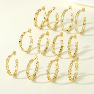Detailed arrangement of six pairs of gold geometric chain link hoop earrings with zircon