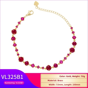 Detail of gold brass bracelet with round red rhinestones and heart charm end