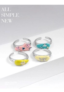 Detail of four colorful enamel open rings with crystal rhinestones on a white background