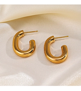 Macro view of 18K gold plated stainless steel chunky C-shape hoop earrings on silk fabric
