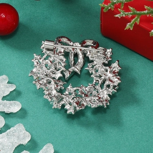 Macro shot of silver Christmas wreath brooch showing the secure safety pin back detail