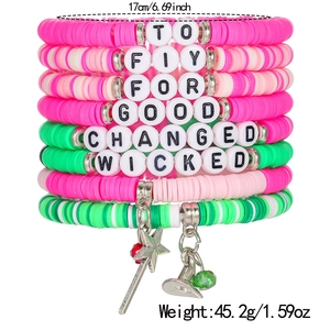 Detail of layered Heishi clay bead bracelets with witch hat and magic wand pendants