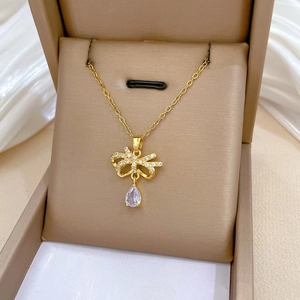 Macro shot of gold butterfly bow necklace with pear-shaped crystal in a jewelry box