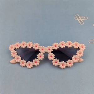 Close-up of cat-eye sunglasses featuring intricate pink floral 3D frame decorations
