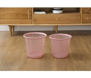 Pink hollow mesh plastic trash bins in large and small sizes on wooden flooring