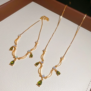 Dettaglio di un set di gioielli placcati in oro con pietre verde smeraldo