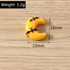 Macro detail of yellow resin moon charm with bat prints for Halloween DIY crafts