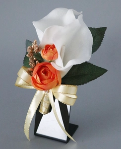 Detail of handmade boutonniere with white calla lily, orange roses and gold berries