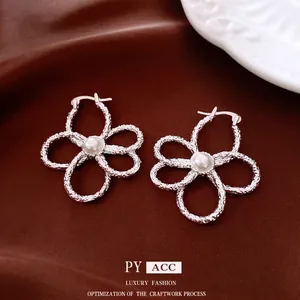 Silver hollow flower earrings with pearls on red silk fabric, minimalist commute style