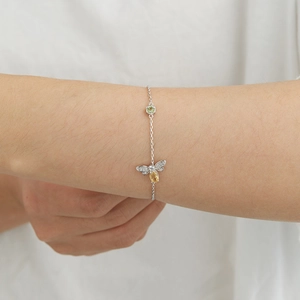 S925 sterling silver bee bracelet with yellow and green gemstones on a model's wrist