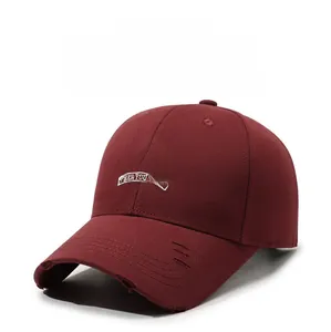Detailed view of the distressed brim and embroidery on a vintage burgundy baseball cap
