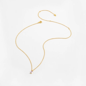 Macro shot of gold necklace featuring a lavender rectangle step-cut gemstone pendant