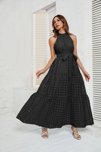 Detail of black halter neck tiered maxi dress showing mesh fabric texture and layered hem