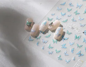 Macro detail of butterfly nail art stickers with mint green gradient and metal 3D accents