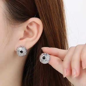 Detail of French cloud pattern earrings with black inlay on polished stainless steel