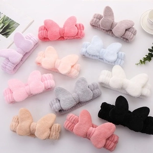Collection of plush OMG bow headbands in various colors including pink, blue, and white