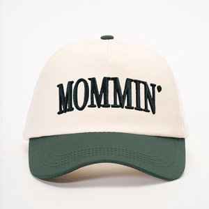 Detailed embroidery of MOMMIN lettering on cream and green adjustable baseball cap