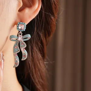 Boucles d'oreilles nœud vintage avec perles bleues et gemmes roses sur un mannequin