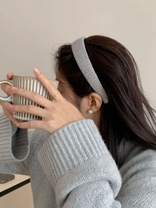 Gros plan d'une fille portant un serre-tête large en tricot gris de style rétro chic