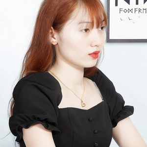 Detail of model wearing the gold cutout heart necklace and matching earrings jewelry set