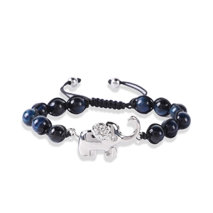 Macro detail of the blue tiger eye stone beads and silver elephant charm on a braided cord