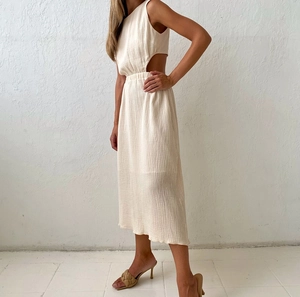 Detail of waist cutout and textured crinkle fabric on sleeveless off-white midi dress