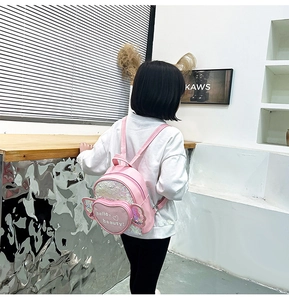 Close-up of pink sequin kids backpack featuring heart pocket and transparent wings detail