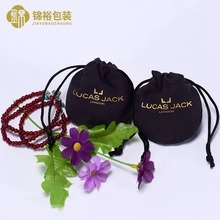 Close-up of black velvet drawstring jewelry pouches with elegant gold printed branding
