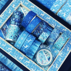 Winter themed washi tape set featuring blue snowflakes and forest motifs on wood tray