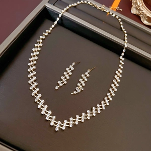 Detailed view of gold jewelry set with necklace and earrings on a brown display tray